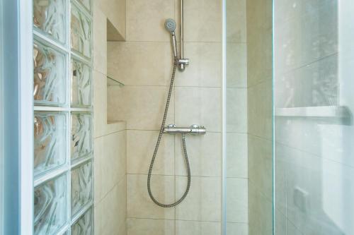 y baño con ducha con cabezal de ducha. en Klimatyczny apartament przy Rynku (1 min. pieszo!), en Wroclaw