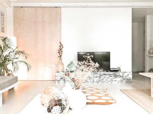 Una sala de estar con un sofá y un televisor. en Casasuul Alvor, en Alvor