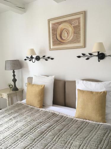 a bedroom with a bed and a picture on the wall at Hôtel Le Pré Saint Michel in Manosque