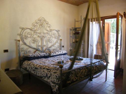 a bedroom with a bed with an ornate headboard at Casolare Casa Ricci in Riotorto