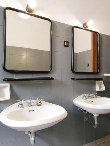 a bathroom with two sinks and two mirrors at Loft - Villa Flore apartments in villa in Casteldaccia