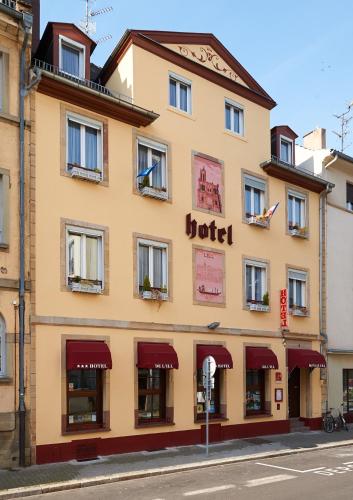 a yellow building with red awnings on a street at Hôtel De L'Ill in Strasbourg