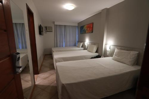 Habitación de hotel con 2 camas y TV en Brasil Express, en Balneário Camboriú