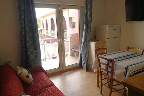 - un salon avec un canapé rouge devant une porte dans l'établissement Appartement T2 avec piscine idéalement situé - aperçu mer, à Anglet