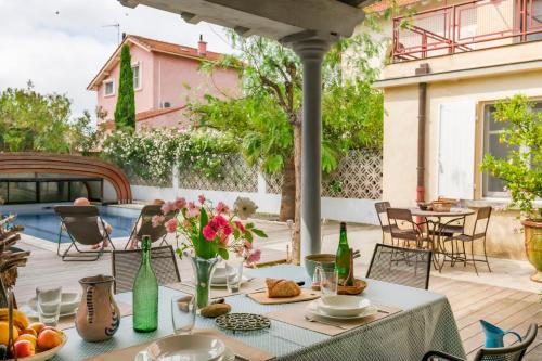 - une table avec de la nourriture et des fleurs sur la terrasse dans l'établissement La Villa ioanes, à Port-Saint-Louis-du-Rhône