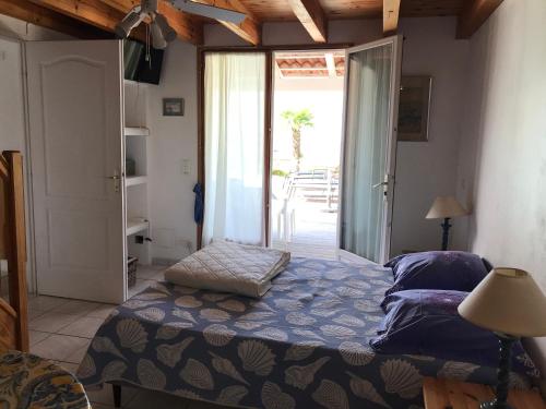 una camera con letto e porta di accesso a un patio di CHAMBRE HOTES CARPE DIEM a Santa-Maria-Poggio