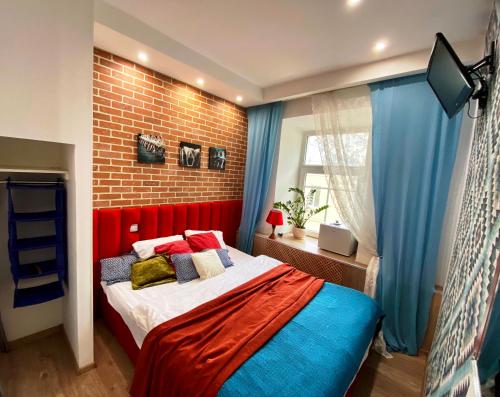 a bedroom with a bed with a red headboard and blue curtains at CityComfort Hotel Kitay- Gorod in Moscow
