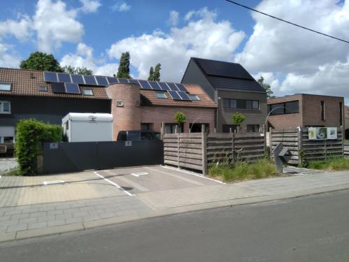 une maison avec des panneaux solaires sur le toit dans l'établissement B&B Tlekkerbeddeke, à Rumst