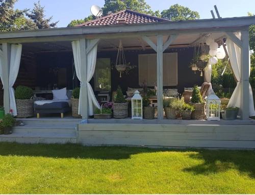 a pavilion with a table and chairs on a lawn at Dom Skandynawski Sen in Wałcz