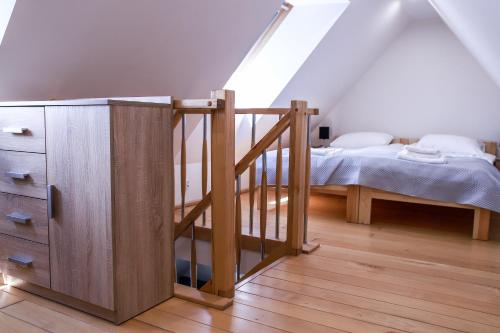 a bedroom with a staircase and a bed in a attic at Apartamenty Mazury Kamienica Centrum in Mrągowo