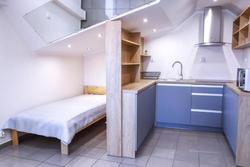a small room with a bed and a sink at Apartamenty Mazury Kamienica Centrum in Mrągowo