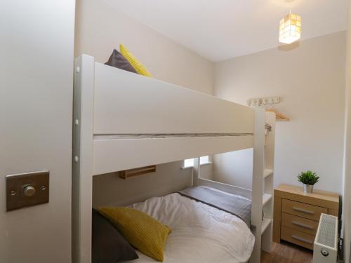 a bedroom with a bunk bed with a white bunk bed at Troopers Cottage in Frome