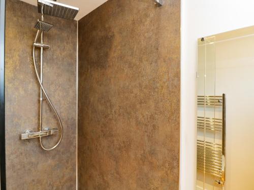 a bathroom with a shower with a glass door at Troopers Cottage in Frome