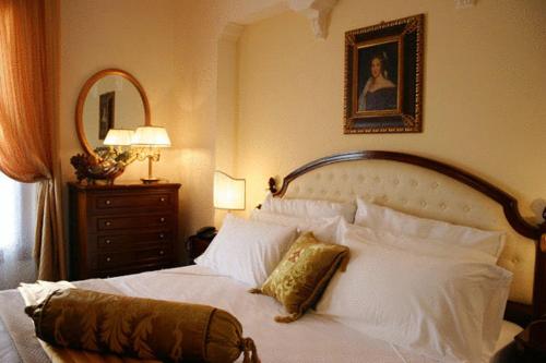 a bedroom with a white bed and a mirror at Grand Hotel Palace in Marsala