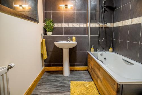 a bathroom with a sink and a bath tub at Modern 2 bedroom garden flat in Inverness