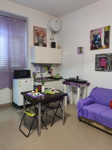 ein Wohnzimmer mit einem Tisch und einer Küche in der Unterkunft FRIDA B&B in Massafra