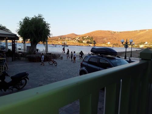 a car parked on a beach with people playing in the water at The house in the port in Korissia