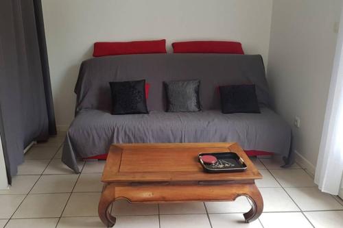 a room with a bed and a coffee table with a couch at Proche de la plage, très bien situé in Ondres