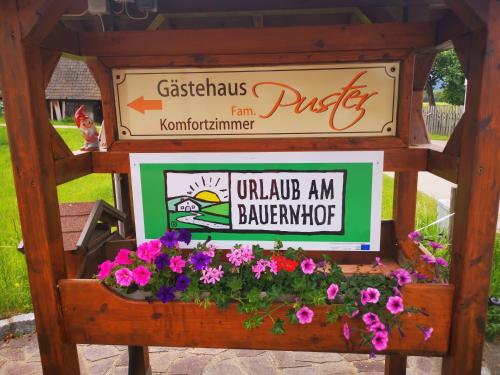 a sign for a restaurant with flowers in a box at Pension Puster in Gobernitz