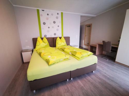 1 dormitorio con 2 camas con almohadas amarillas en Pension Puster en Gobernitz