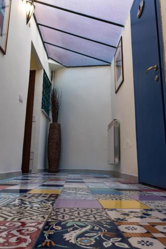a hallway with a blue door and a tile floor at Antica Terrazza Frascati in Frascati