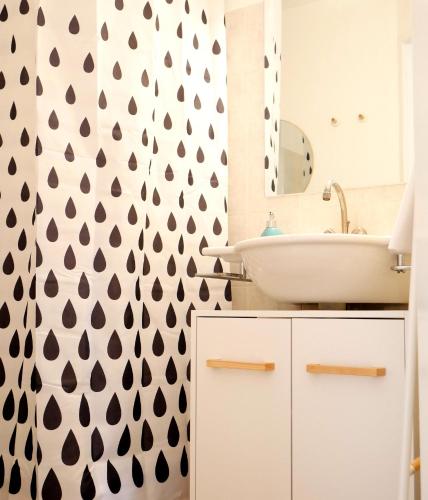 une salle de bain avec un lavabo blanc et un miroir dans l'établissement Futurostudio - Appart Hôtel Futuroscope Nintendo - site du Futuroscope - Poitiers, à Jaunay-Clan