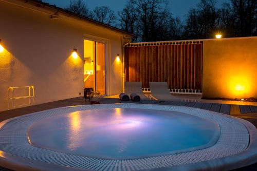 a large swimming pool in a backyard at night at L'Orée du Bois in Vittel