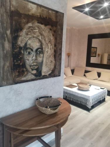 a living room with a portrait of a woman on the wall at Ático Aretusa in Zahara de los Atunes