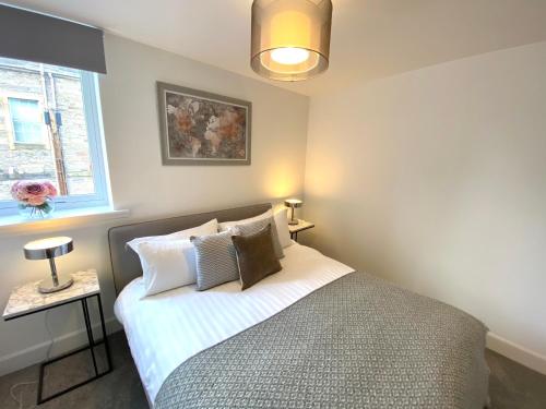 a bedroom with a bed with pillows and a window at High Street Stylish City Centre Apartment, 2 Bed in Perth