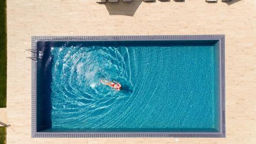 a person swimming in a pool with a wave at Aparthotel Malga in Caldaro
