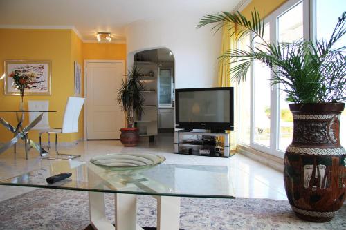 a living room with a tv and a glass table at Penthaus Villa Erika Madeira in Caniço