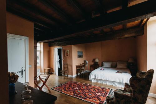 Saint-Antoine-de-BreuilhにあるChambres d'Hôtes La Bastide des Trémièresのベッドルーム1室(ベッド1台付)、リビングルームが備わります。