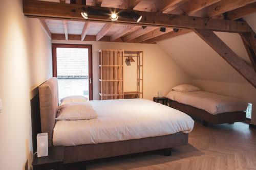 een slaapkamer met 2 bedden op een zolder bij Sint-Jacobshoeve 2 in Oudenaarde