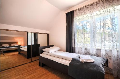 a bedroom with two beds and a large window at Willa Luiza in Wisła