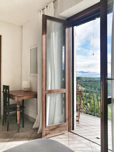 a room with a sliding glass door with a table at Villa Belvedere Langhe in Belvedere Langhe