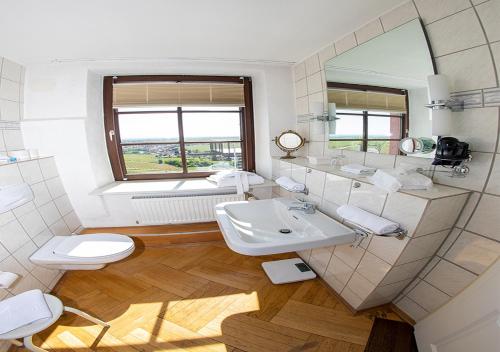 a bathroom with a sink and a toilet and a mirror at Hotel Zum Burggraf in Neuleiningen