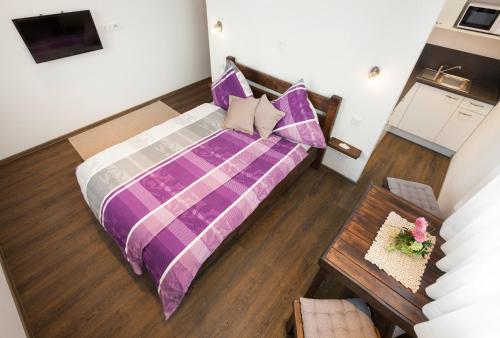 einen Blick über ein Schlafzimmer mit einem lila Bett in der Unterkunft Pension SiLa in Groß-Umstadt
