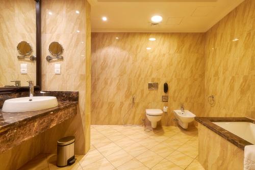 a bathroom with a sink and a toilet at Bahi Ajman Palace Hotel in Ajman 