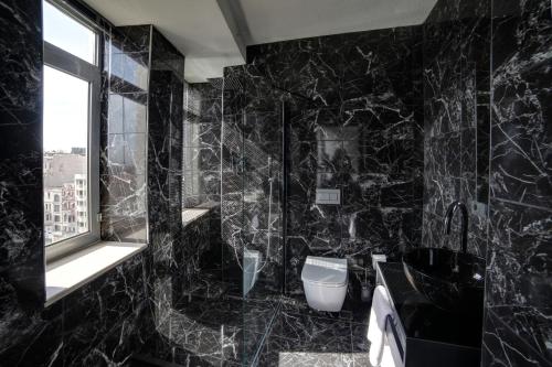 a black bathroom with a toilet and a window at Taksim Seya Suites Hotel in Istanbul