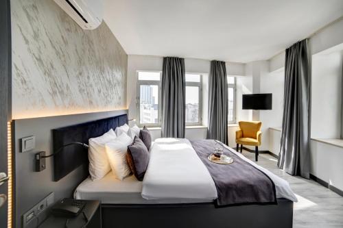 a hotel room with a large bed and a chair at Taksim Seya Suites Hotel in Istanbul