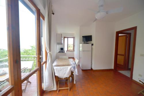 a small kitchen with a table and a refrigerator at Case vacanza Barbatoja in Fetovaia