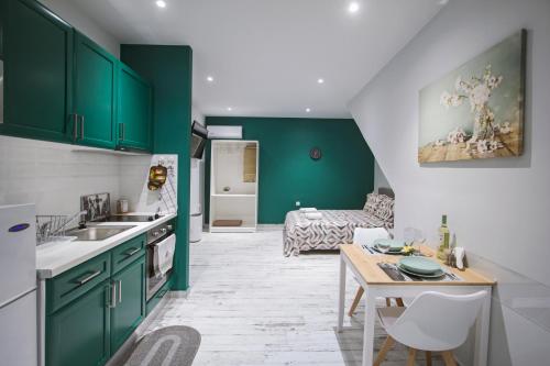 uma cozinha com armários verdes, uma mesa e um sofá em T.G. Corfu Studios em Corfu Town