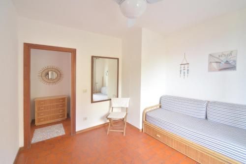 a bedroom with a bed and a mirror and a chair at Case vacanza Barbatoja in Fetovaia