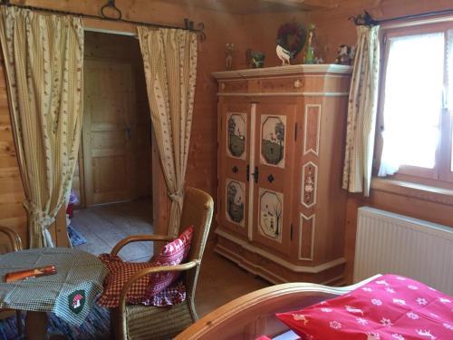 a room with a table and a cabinet and a window at Blockhaus-Traum Huber in Garmisch-Partenkirchen