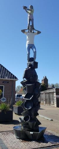 a statue of a man standing on top of a pile of shoes at Herberg Boswijck, B&B in Wijckel