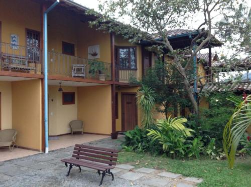 a wooden bench sitting outside of a building at Pousada das Pedras Paraty -RJ in Paraty