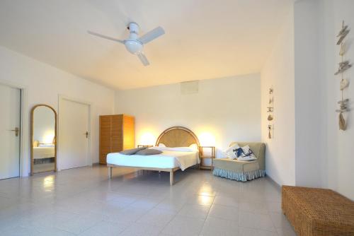 a bedroom with a bed and a ceiling fan at Case vacanza Barbatoja in Fetovaia