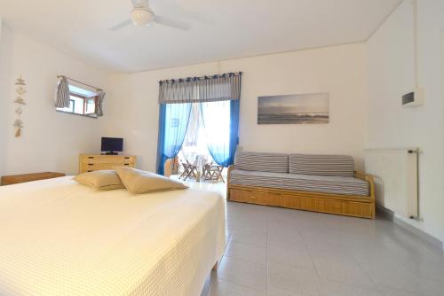a bedroom with a large bed and a couch at Case vacanza Barbatoja in Fetovaia