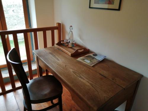a wooden table with a lamp and a book on it at La Gaucherie aux Dames in Vihiers