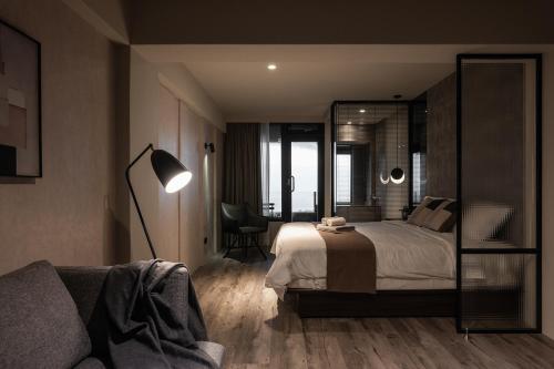 a bedroom with a bed with a mirror and a couch at Something Easy Inn in Jiufen